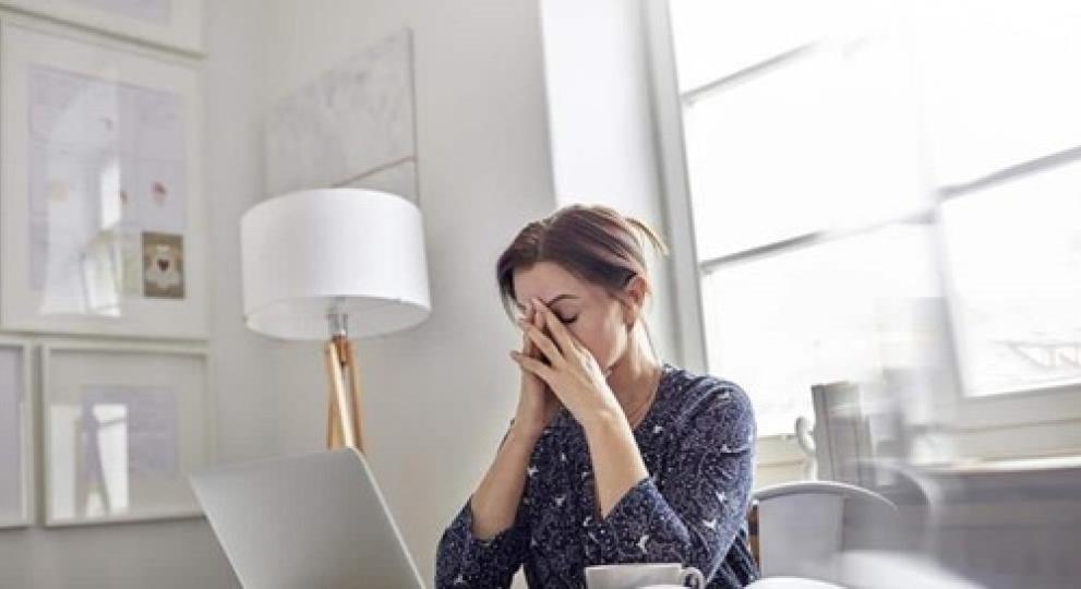 Mujer cansada delante de un portatil